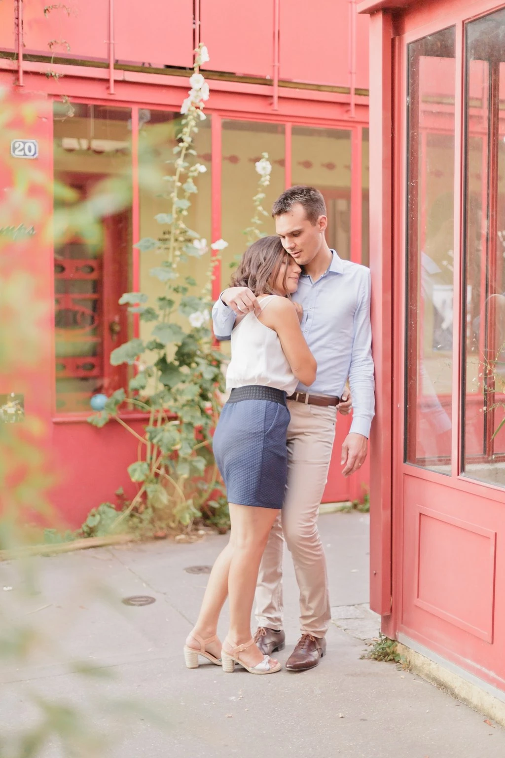 Séance couple tendresse devant façade rose, complicité et douceur, lumière dorée naturelle, ambiance intemporelle et élégante