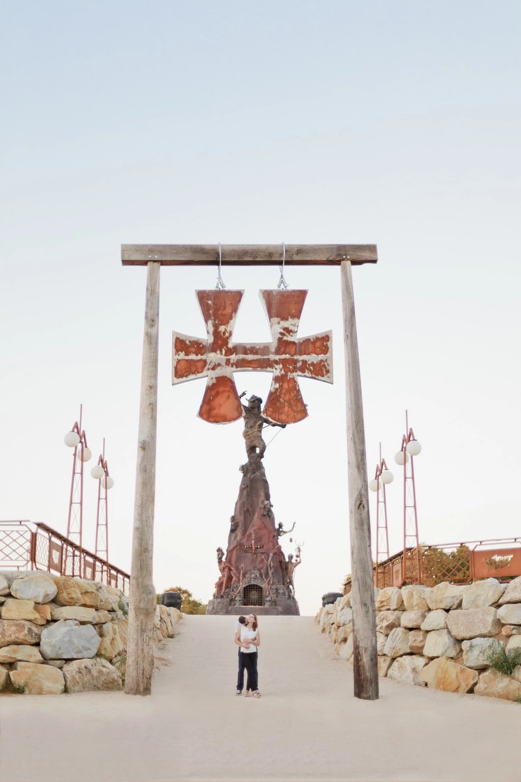 Jeune fille seule sous un portique monumental avec cloches rouges, lumière douce et ciel dégagé, ambiance contemplative et poétique