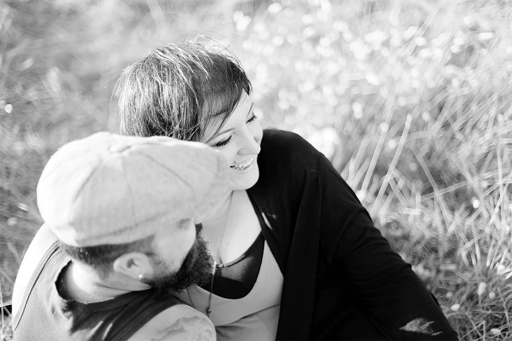 Séance photo famille en noir et blanc : mère et enfant en complicité tendre dans la nature, moment d'intimité douce et authentique en extérieur