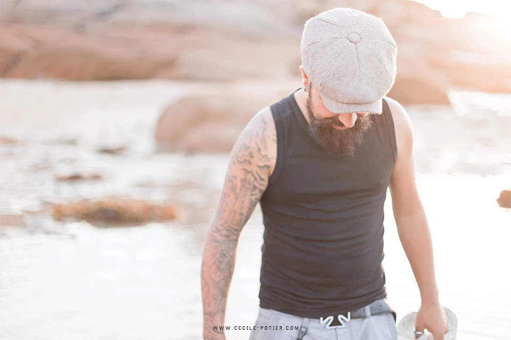 Portrait authentique d'un homme à la plage en lumière dorée, ambiance introspective et sereine, séance lifestyle en bord de mer