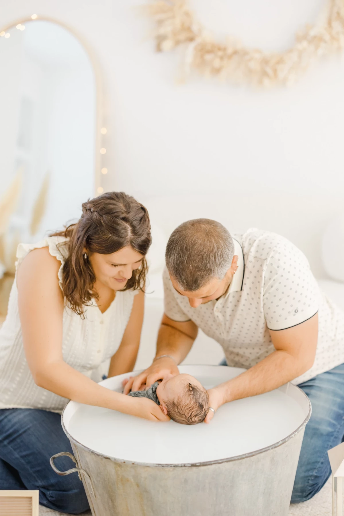 Séance bain bébé au studio : parents attentionnés prennent soin de leur nouveau-né lors d'un moment de tendresse et complicité