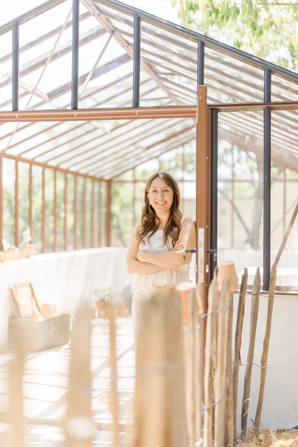 Cécile Potier se tient à l'entrée de la Verrière, son studio sous serre à La Boissière-de-Montaigu, baigné de lumière naturelle.