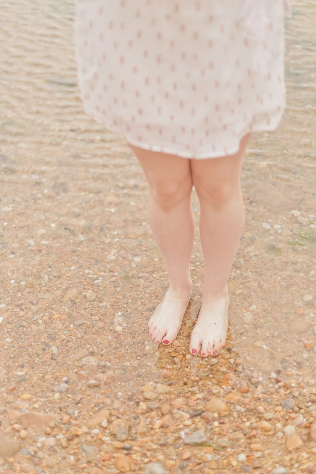 Séance photo enfant pieds nus sur plage, robe blanche dentelle, moment de tendresse et authenticité en bord de mer