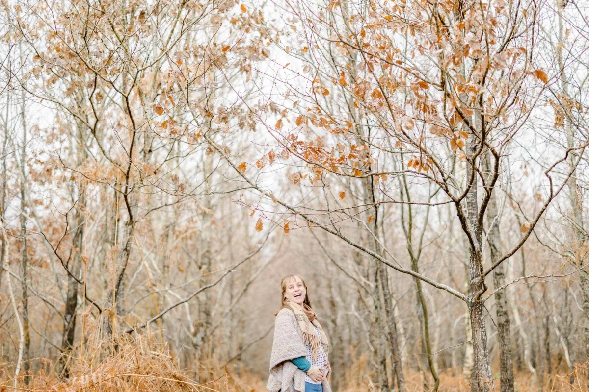 Séance photo famille automne en forêt - Jeune fille souriante parmi les arbres nus - Ambiance poétique et intemporelle en Vendée
