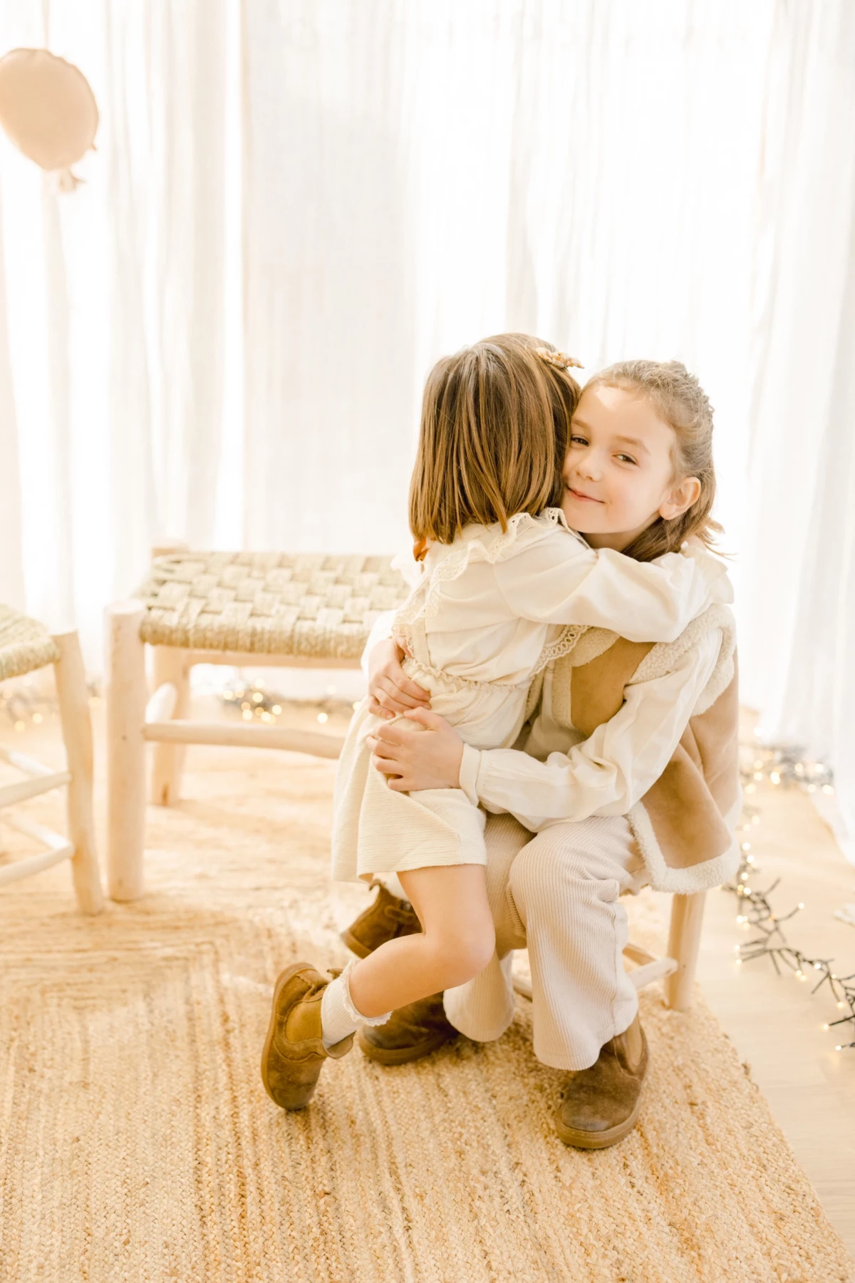 Séance famille en studio : deux enfants partagent un câlin complice dans une ambiance lumineuse et chaleureuse en Vendée