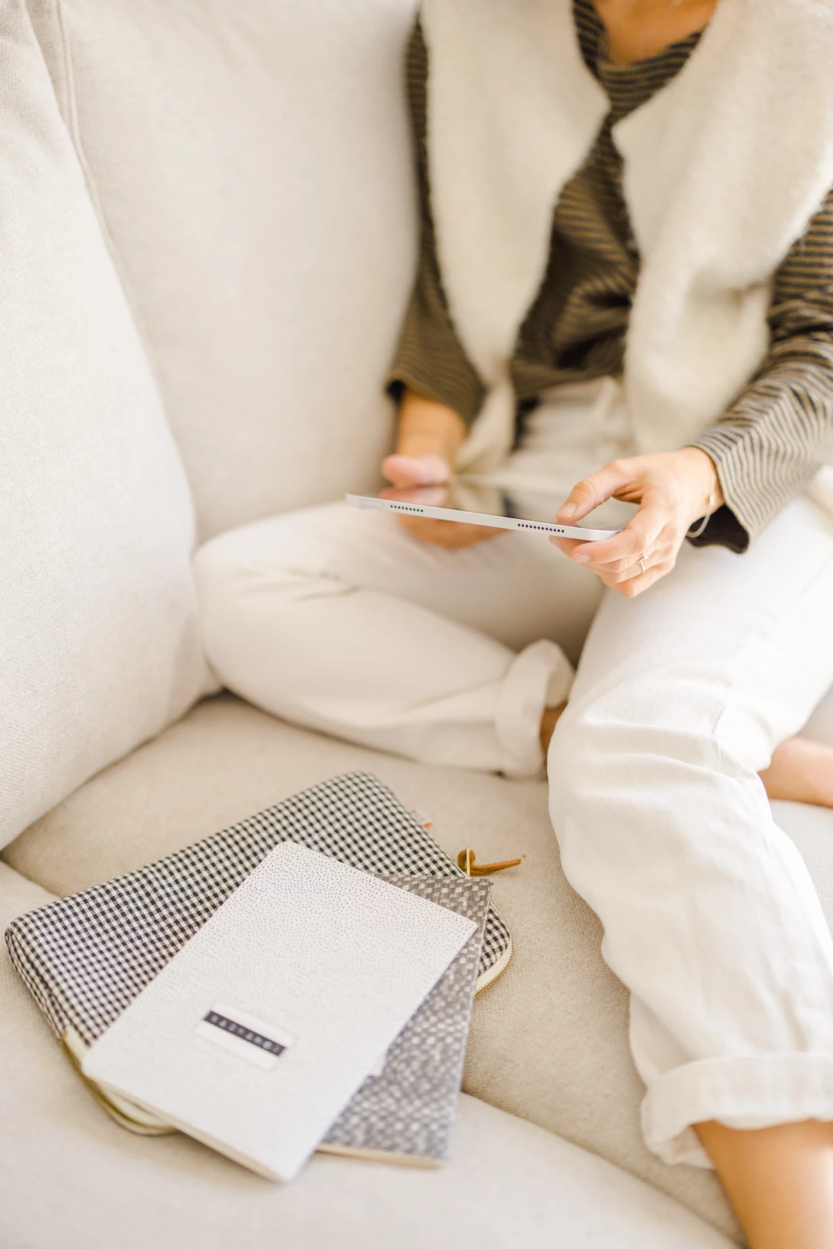 Mère et enfant partageant un moment de lecture sur un canapé blanc, mains délicates tenant un livre