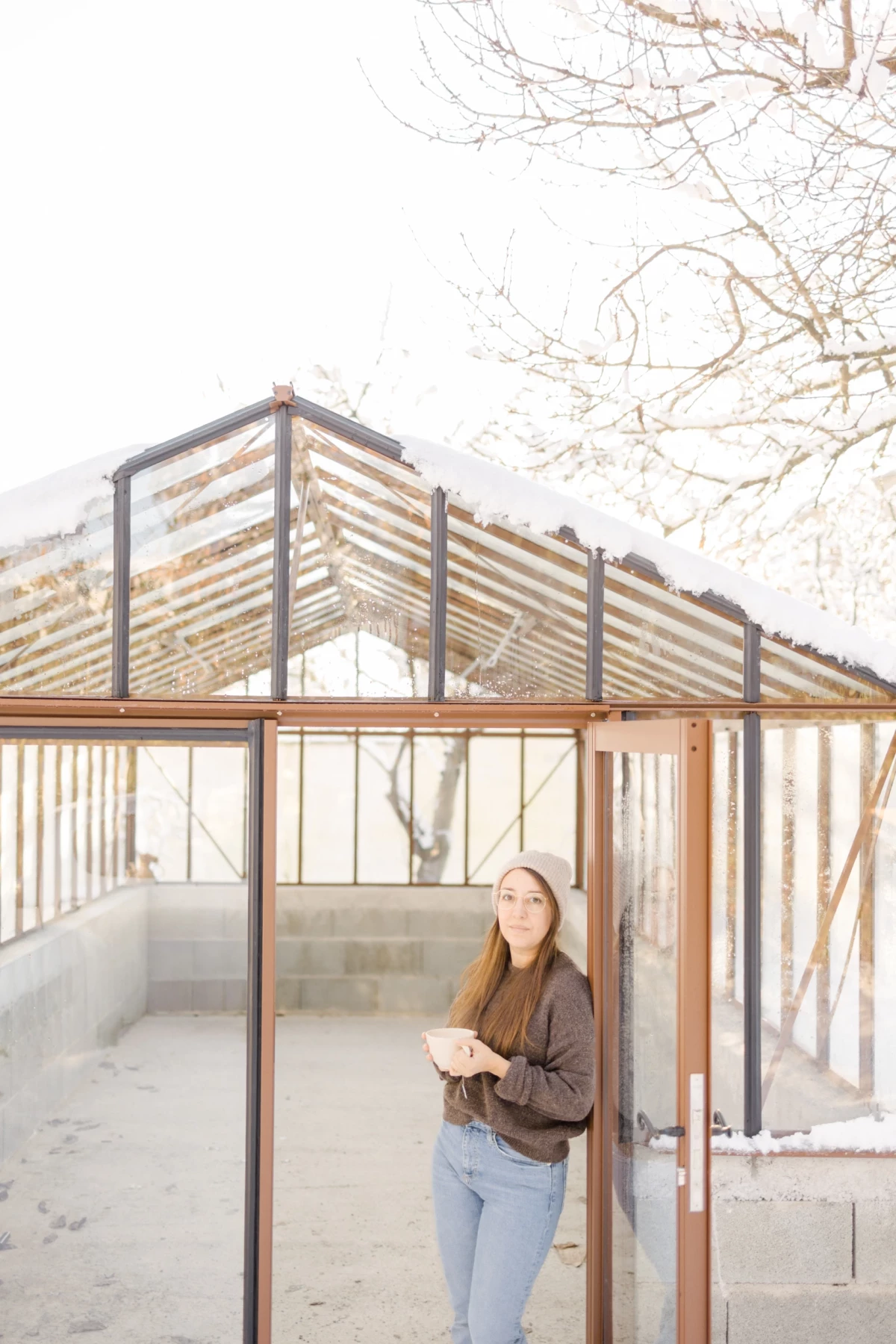 Portrait professionnel en extérieur d'une femme consultant une tablette dans une serre architecturale