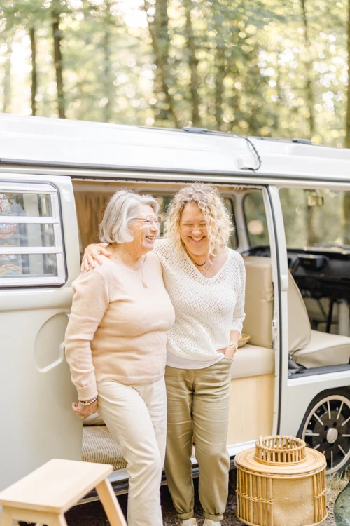 Séance famille en van vintage : grand-mère et fille adulte complices dans une ambiance chaleureuse et lumineuse en forêt