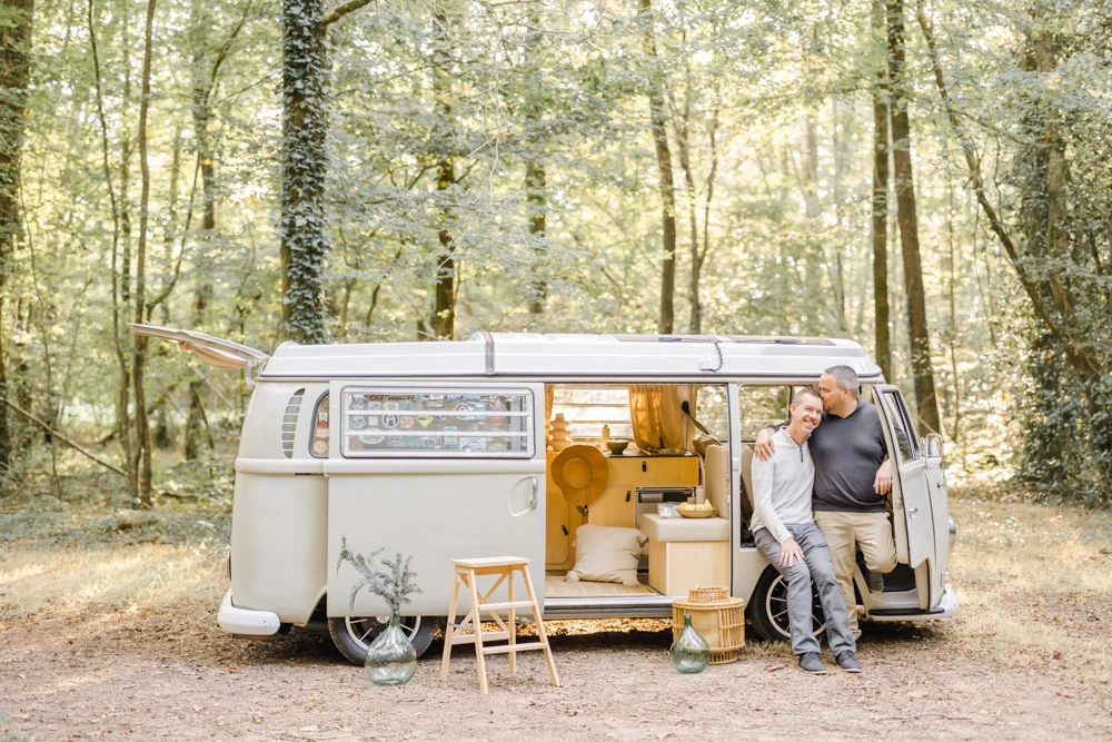 Séance famille dans une camionnette vintage en forêt, parents et enfants dans une ambiance chaleureuse et intime entourés de lumière dorée