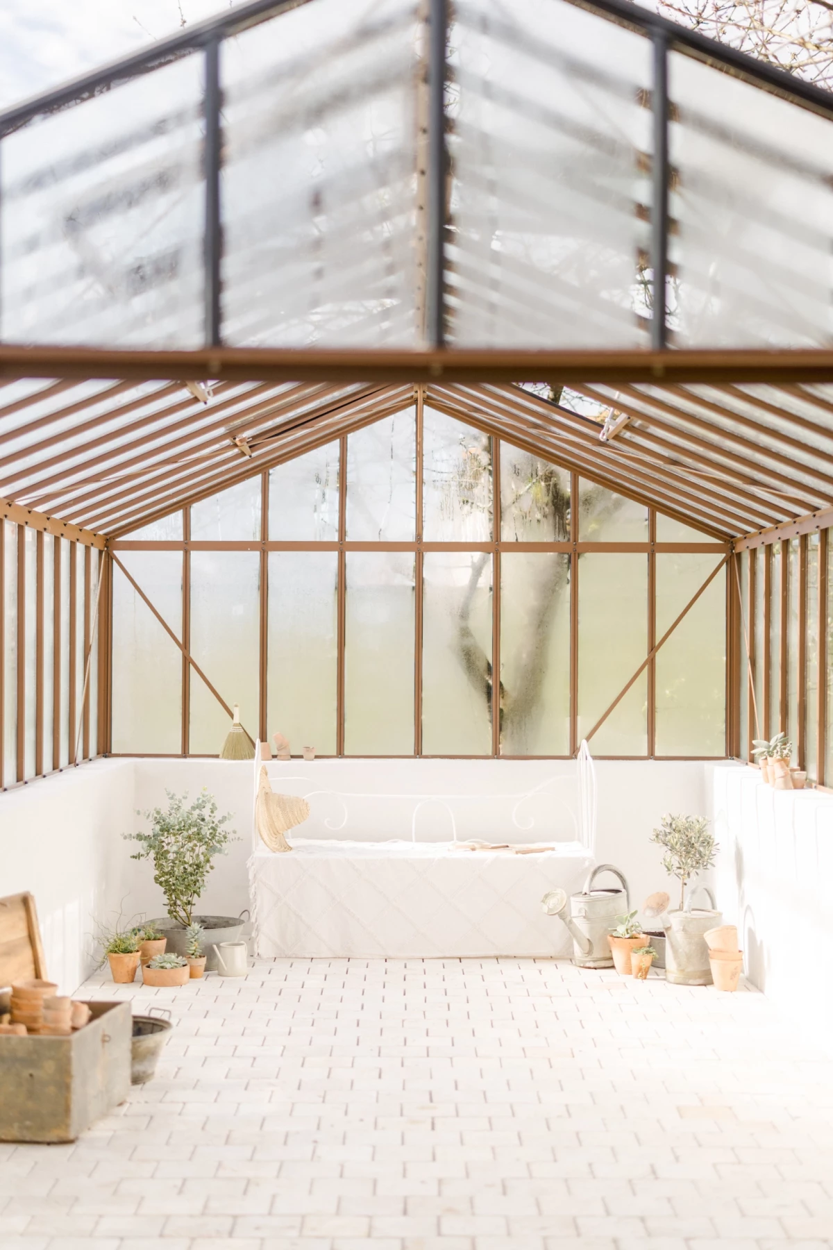 Studio photo avec verrière et charpente apparente, lumière naturelle et décoration épurée en tons blancs et beiges, Vendée