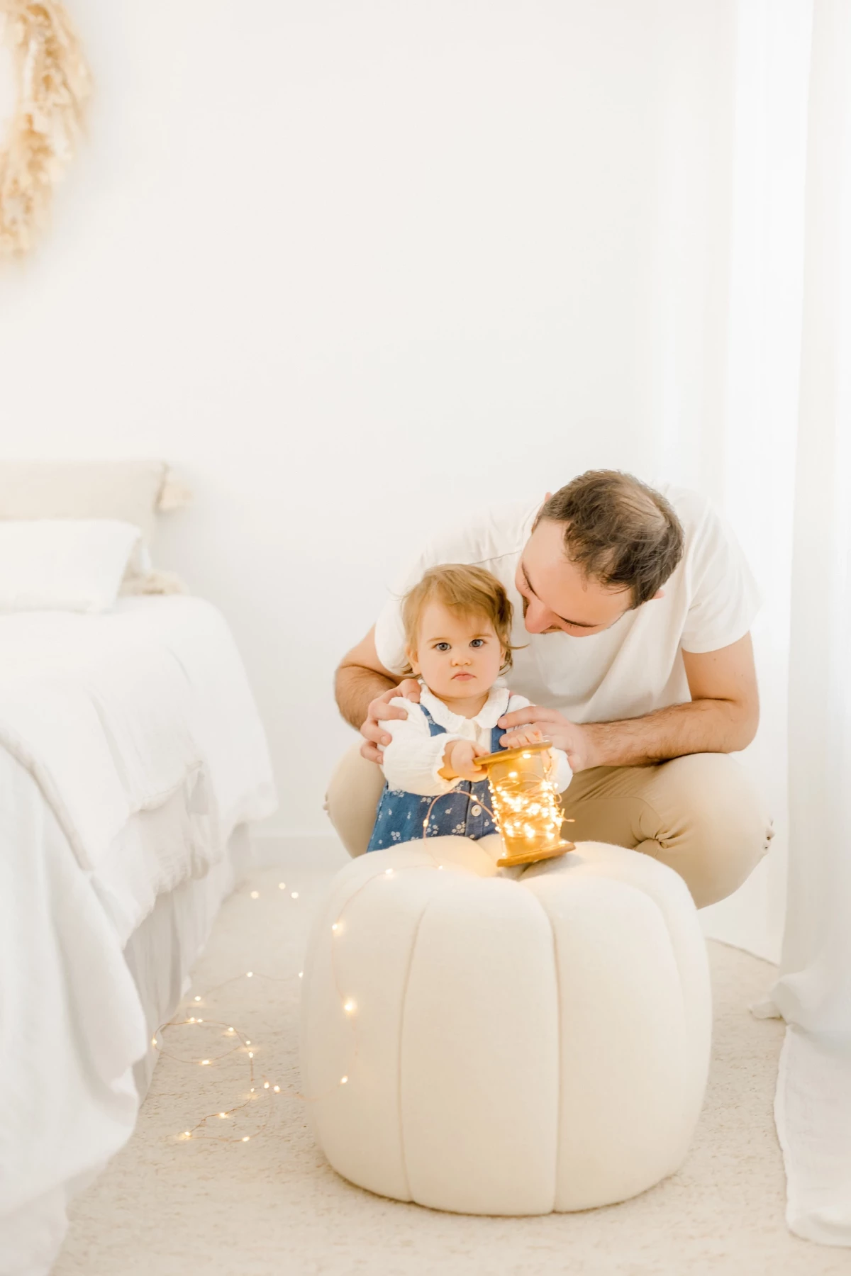 Séance famille au studio : parent et petite fille partagent un moment de complicité et de tendresse dans une ambiance lumineuse