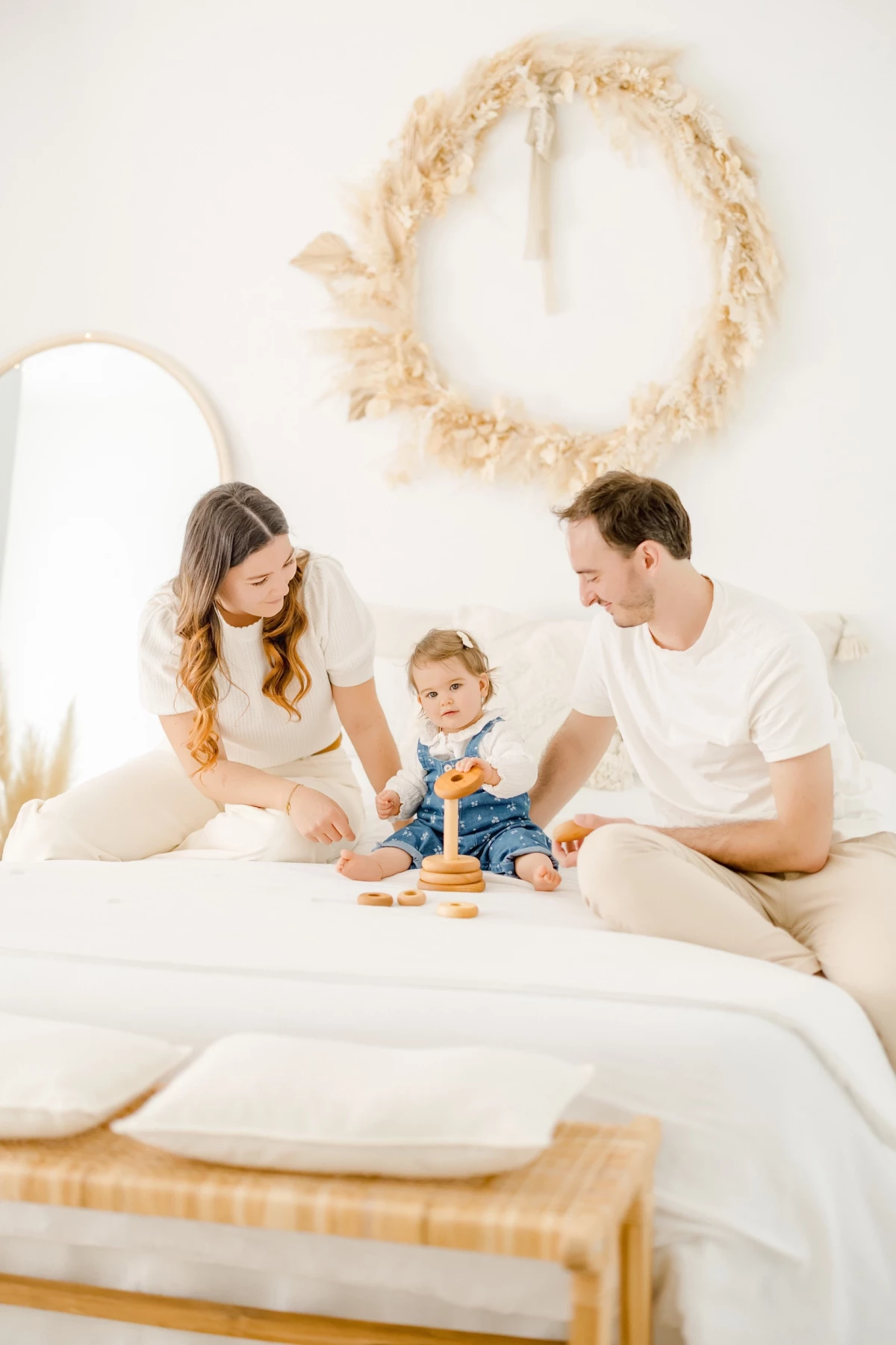 Séance famille au studio : parents et bébé partagent un moment de jeu et de complicité dans une ambiance douce et naturelle