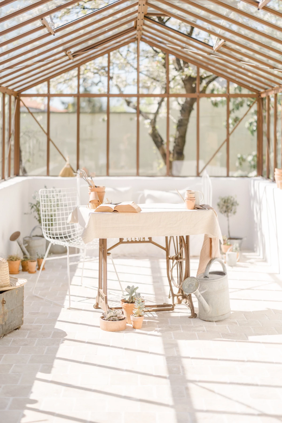 Séance famille en verrière : mère et fille partagent un moment de jardinage dans une lumière printanière douce et naturelle