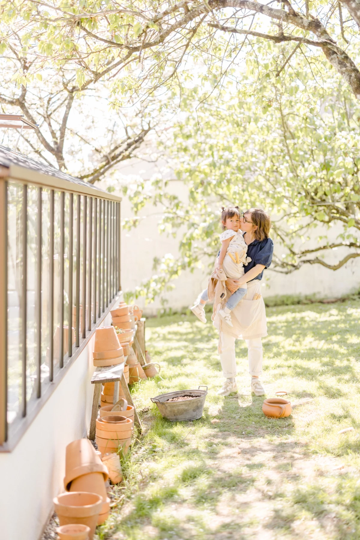 Séance famille en extérieur : mère et fille partagent un moment de complicité printanière dans un jardin ensoleillé en Vendée