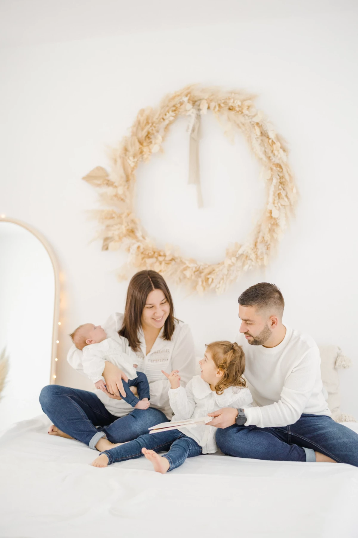 Séance naissance en studio : parents et deux enfants réunis dans un moment de douceur et de complicité familiale