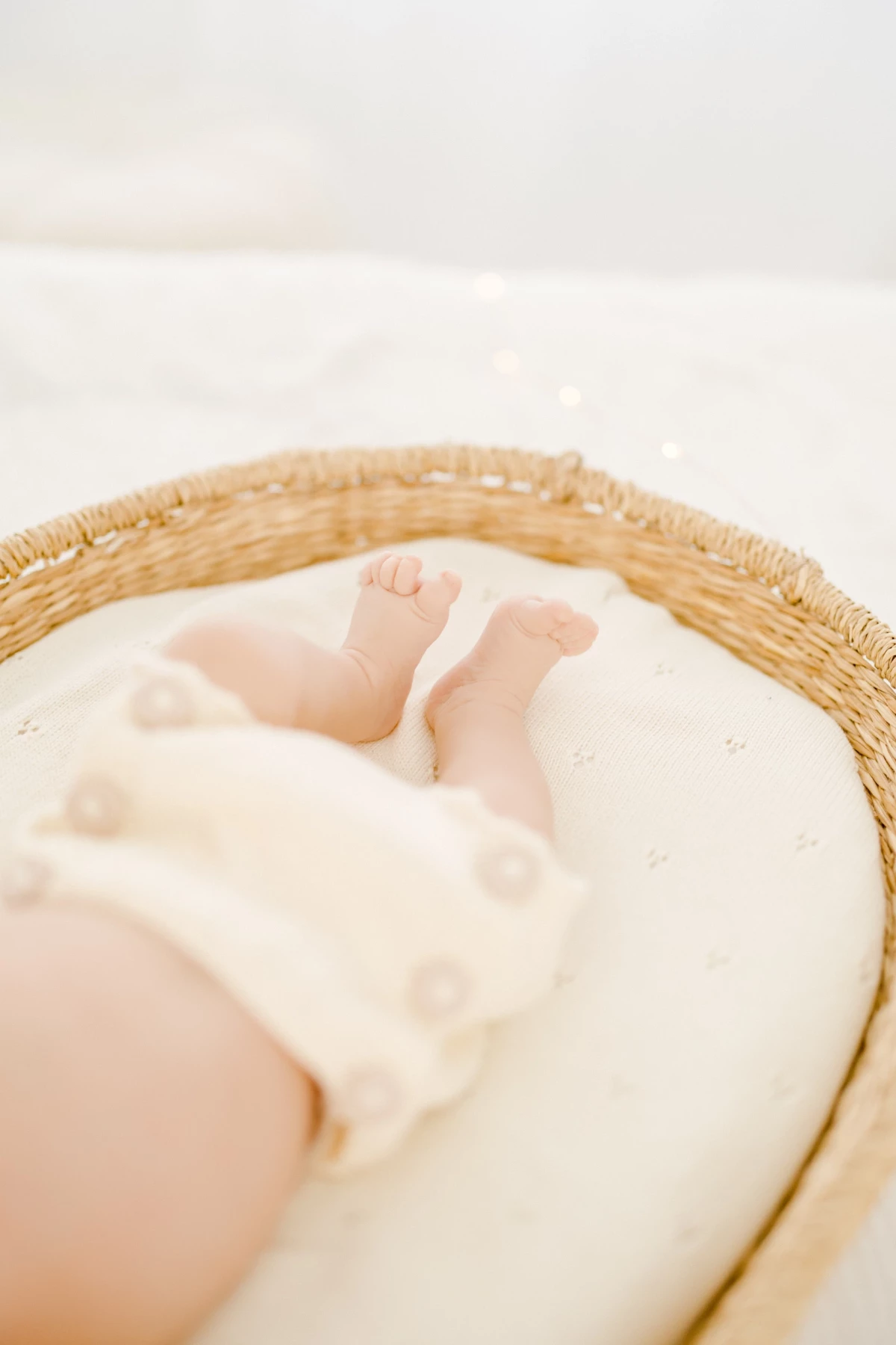 Séance naissance au studio : pieds de nouveau-né enveloppé dans un lange doux, instant de tendresse capturé en lumière naturelle