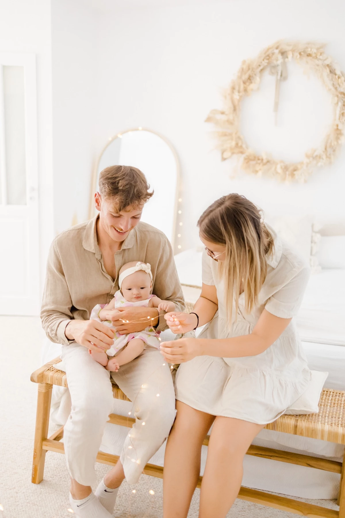 Séance naissance en studio : jeunes parents complices avec leur bébé de 4 mois, ambiance douce et lumineuse aux tons naturels