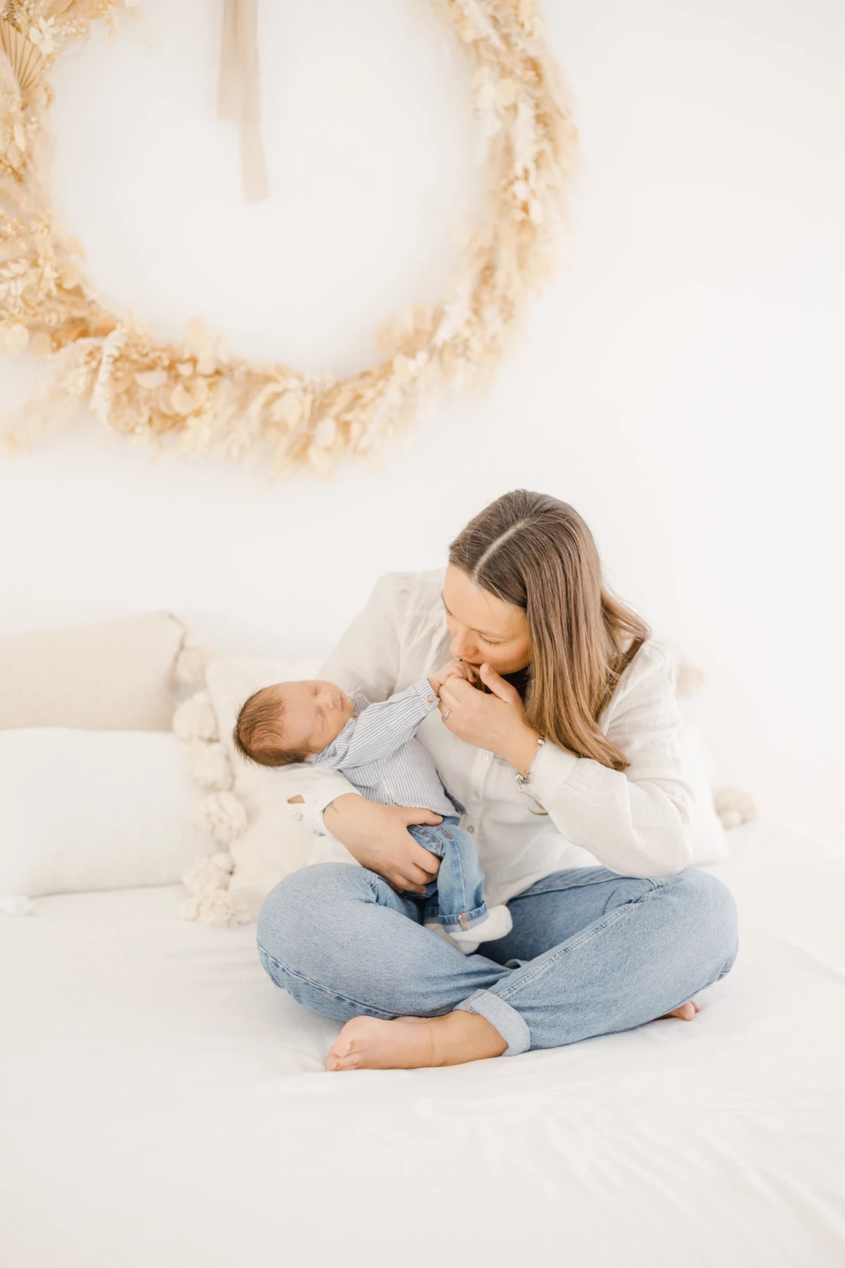 Séance naissance en studio : maman allaite son nouveau-né dans une ambiance douce et lumineuse, instant de tendresse maternelle