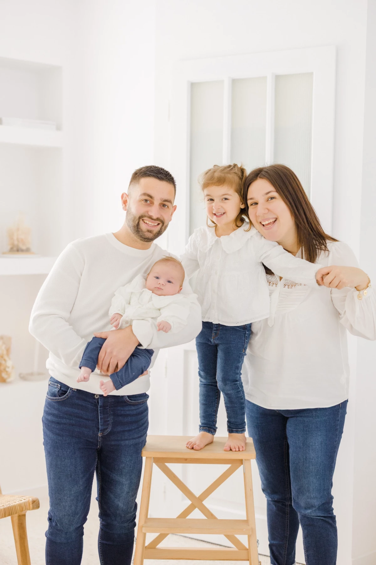 Séance naissance en studio : famille heureuse avec nouveau-né et enfant, ambiance lumineuse et tendre en Vendée