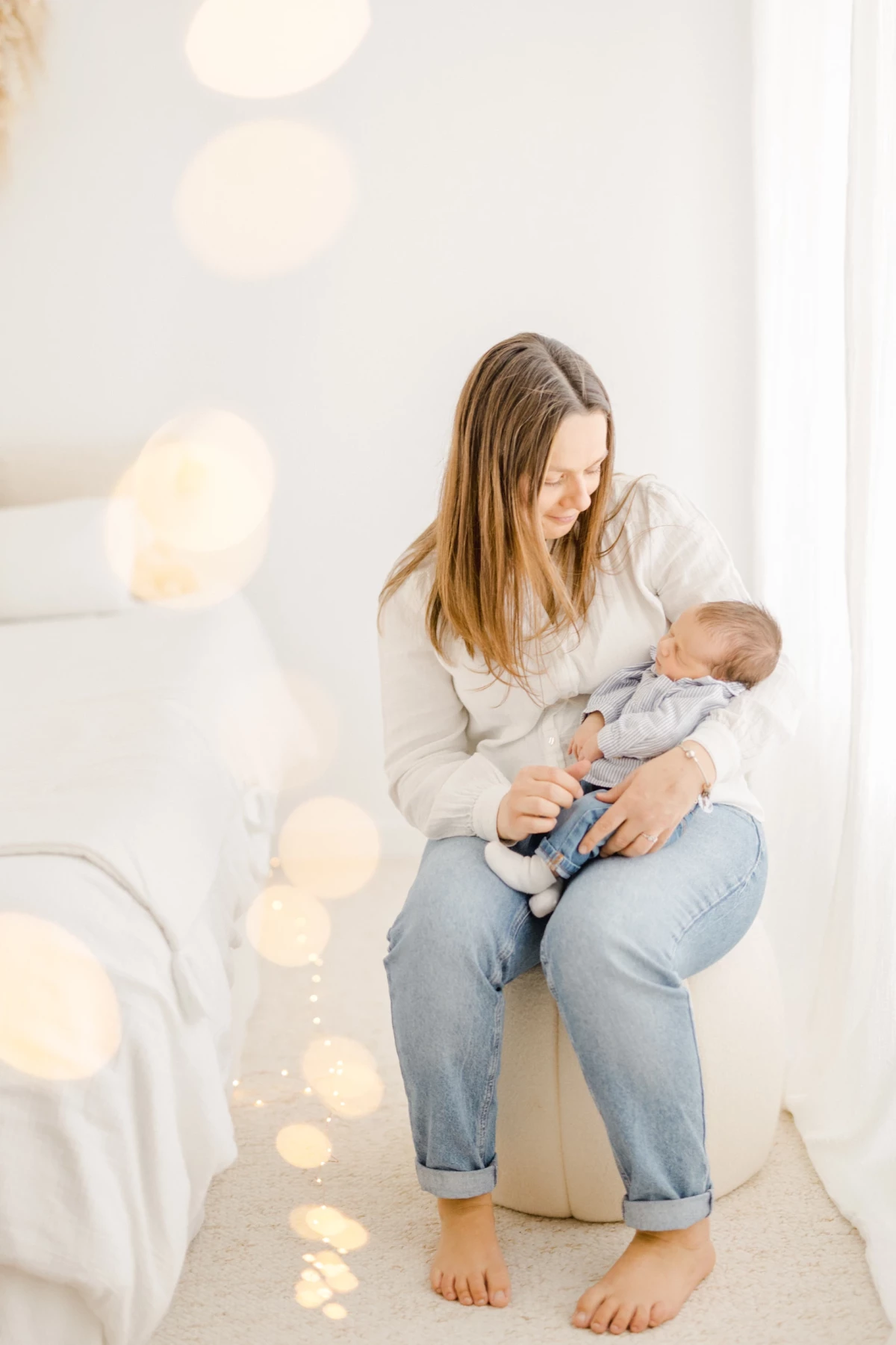 Séance naissance au studio : jeune maman allaite son nouveau-né dans une ambiance de douceur et lumière naturelle en Vendée