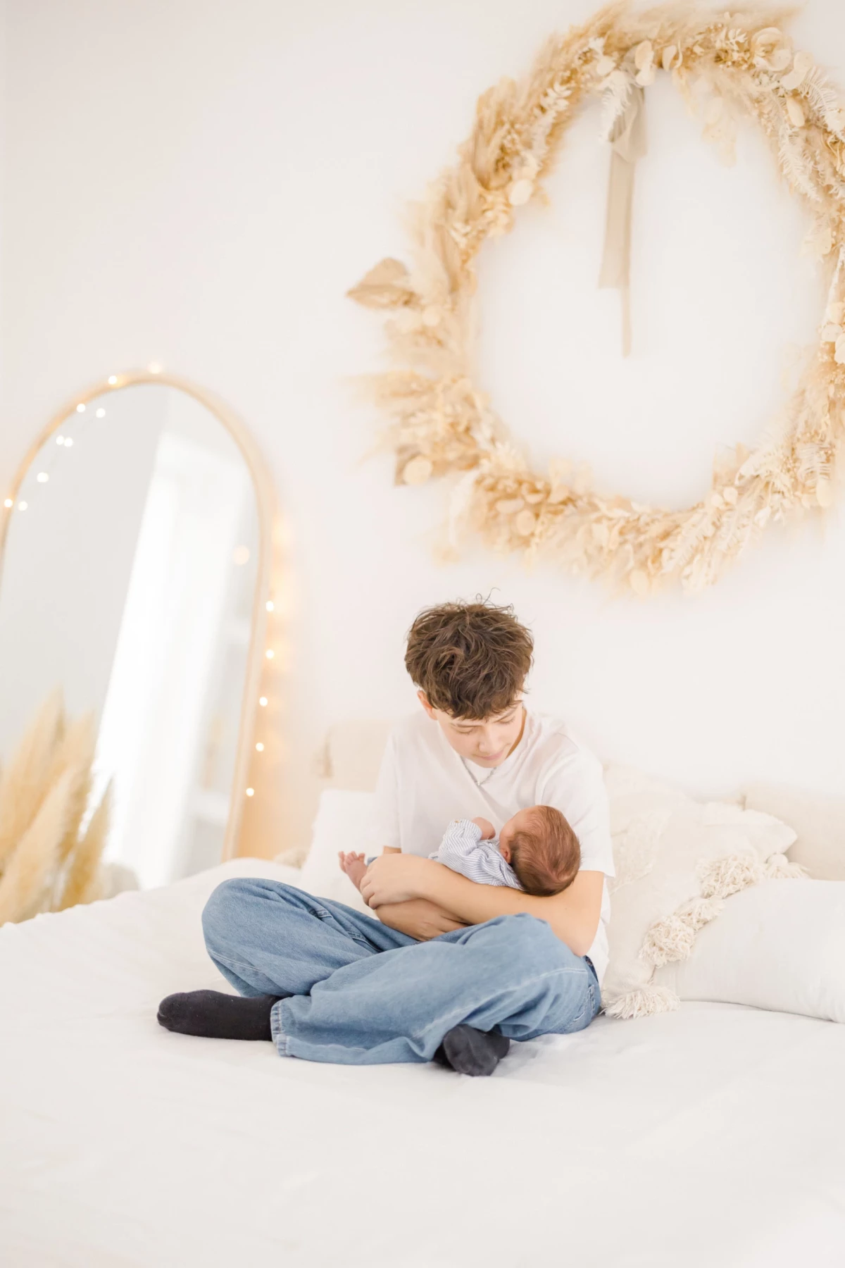 Séance naissance au studio : parent allaite son nouveau-né dans une ambiance cocooning empreinte de douceur et d'intimité