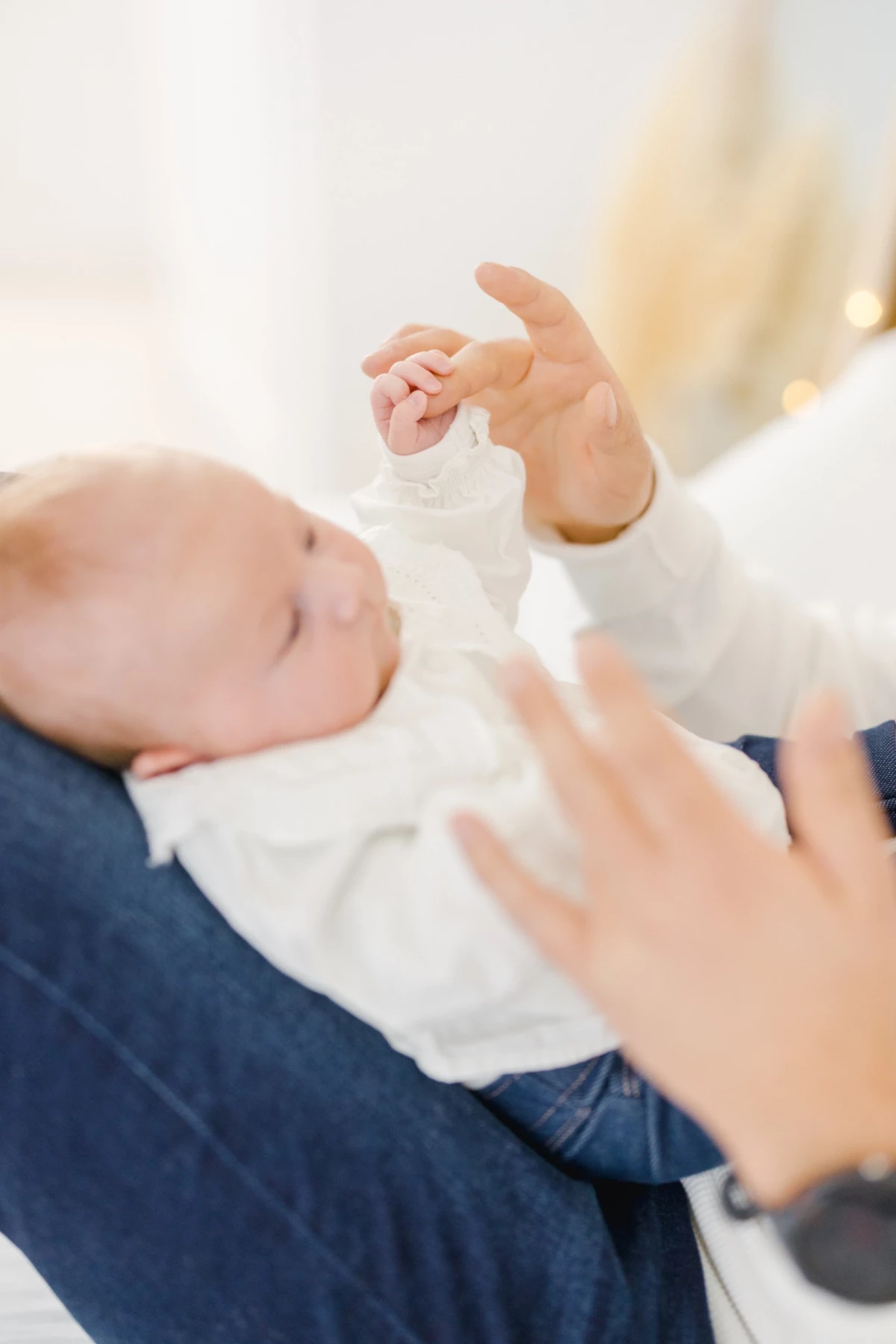 Séance naissance en studio : maman administre des gouttes à son bébé avec tendresse et douceur dans une ambiance intimiste