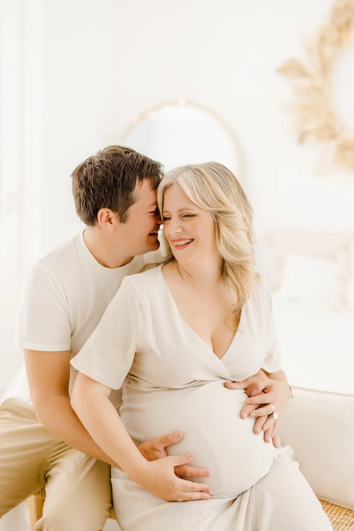 Séance grossesse studio Vendée : couple complice enlace le ventre rond, instant de tendresse douce et lumineuse