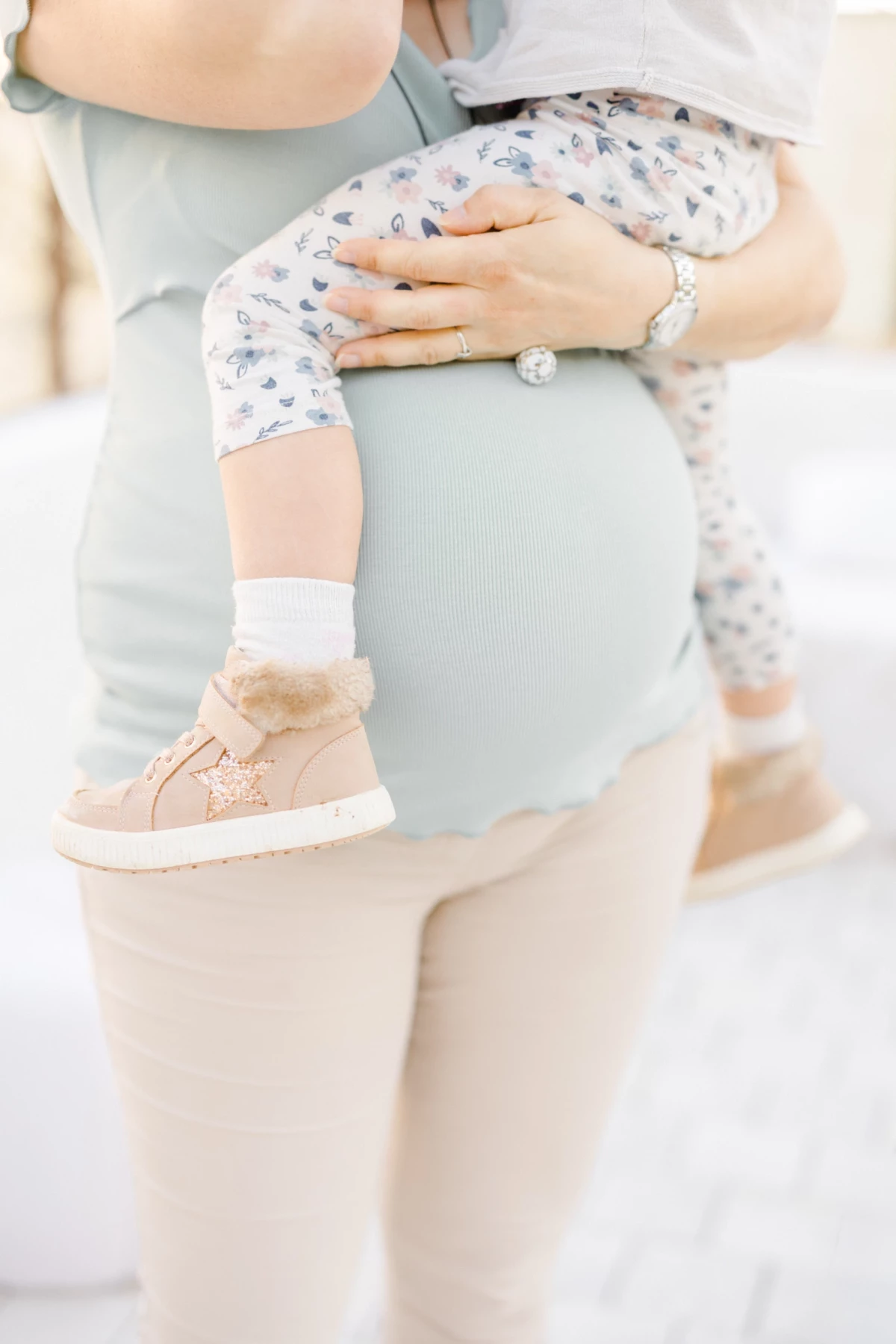 Séance grossesse en studio : future maman porte son enfant, moment de complicité et tendresse dans une ambiance douce et lumineuse