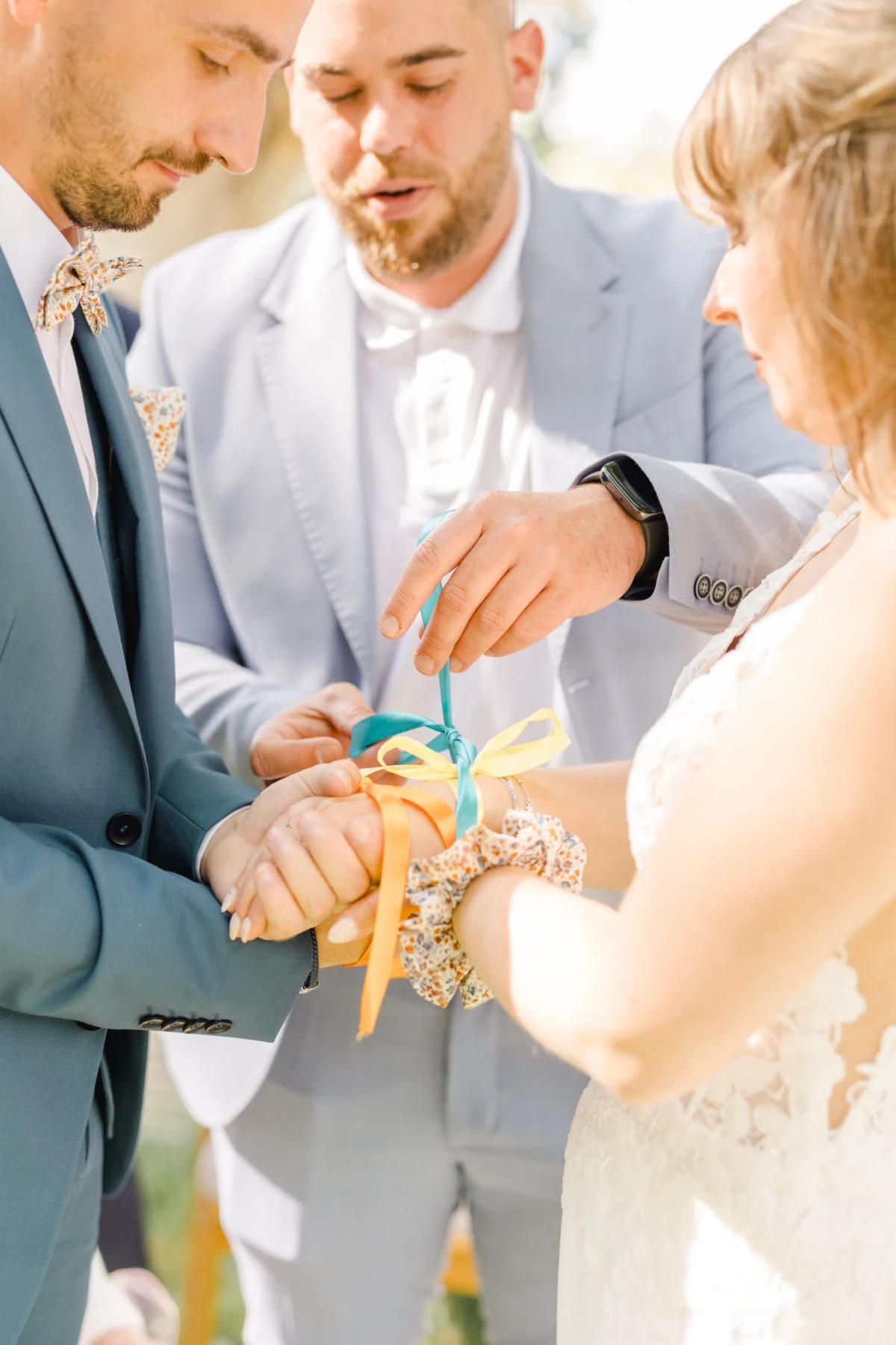 Couple de mariés attachant un ruban coloré lors d'un rituel symbolique de cérémonie laïque