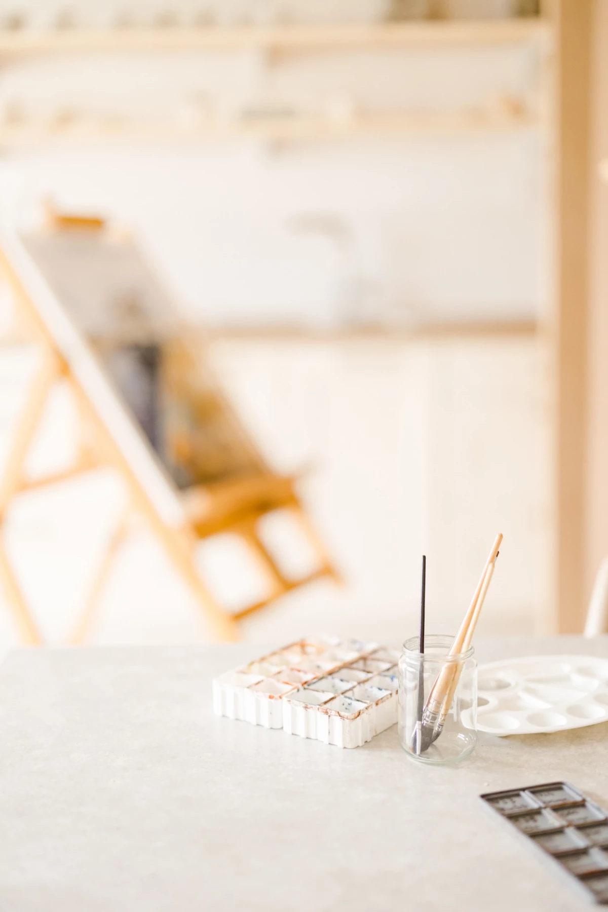 Portrait corporate dans un atelier créatif : outils de céramique et aquarelle sur table claire, ambiance artisanale et douce