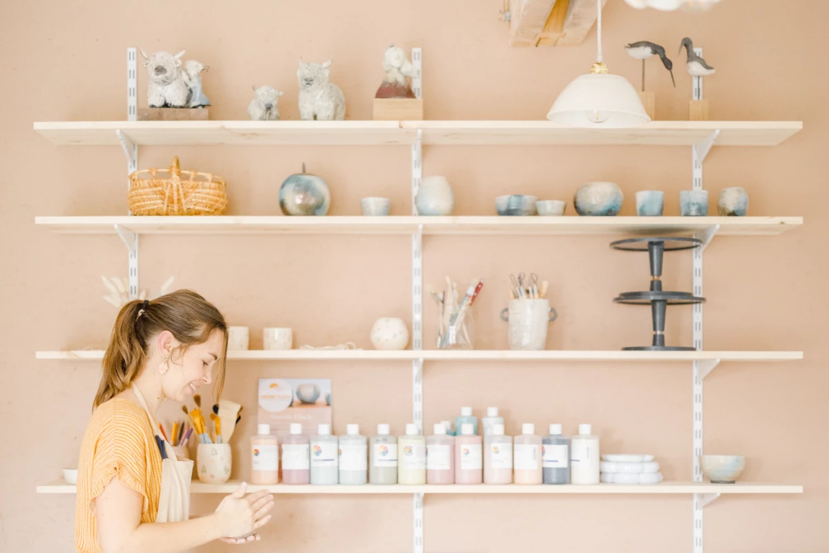 Portrait corporate artisan céramiste dans son atelier lumineux, ambiance beige et douce, authenticité professionnelle en Vendée