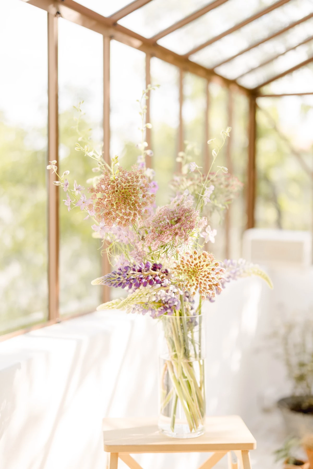 Séance corporate fleuriste Vendée : bouquet de fleurs champêtres dans une verrière lumineuse, ambiance douce et naturelle
