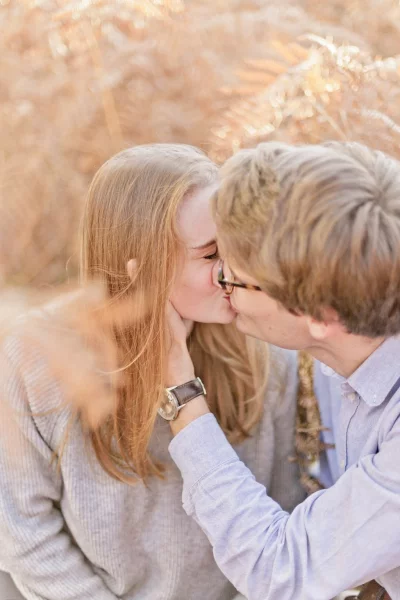 Jeune couple s'embrassant tendrement dans une ambiance bohème aux tons beige et neutres